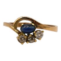 A POLISH 14CT GOLD, SAPPHIRE AND DIAMOND STYLISED CROSSOVER RING Having oval cabochon cut