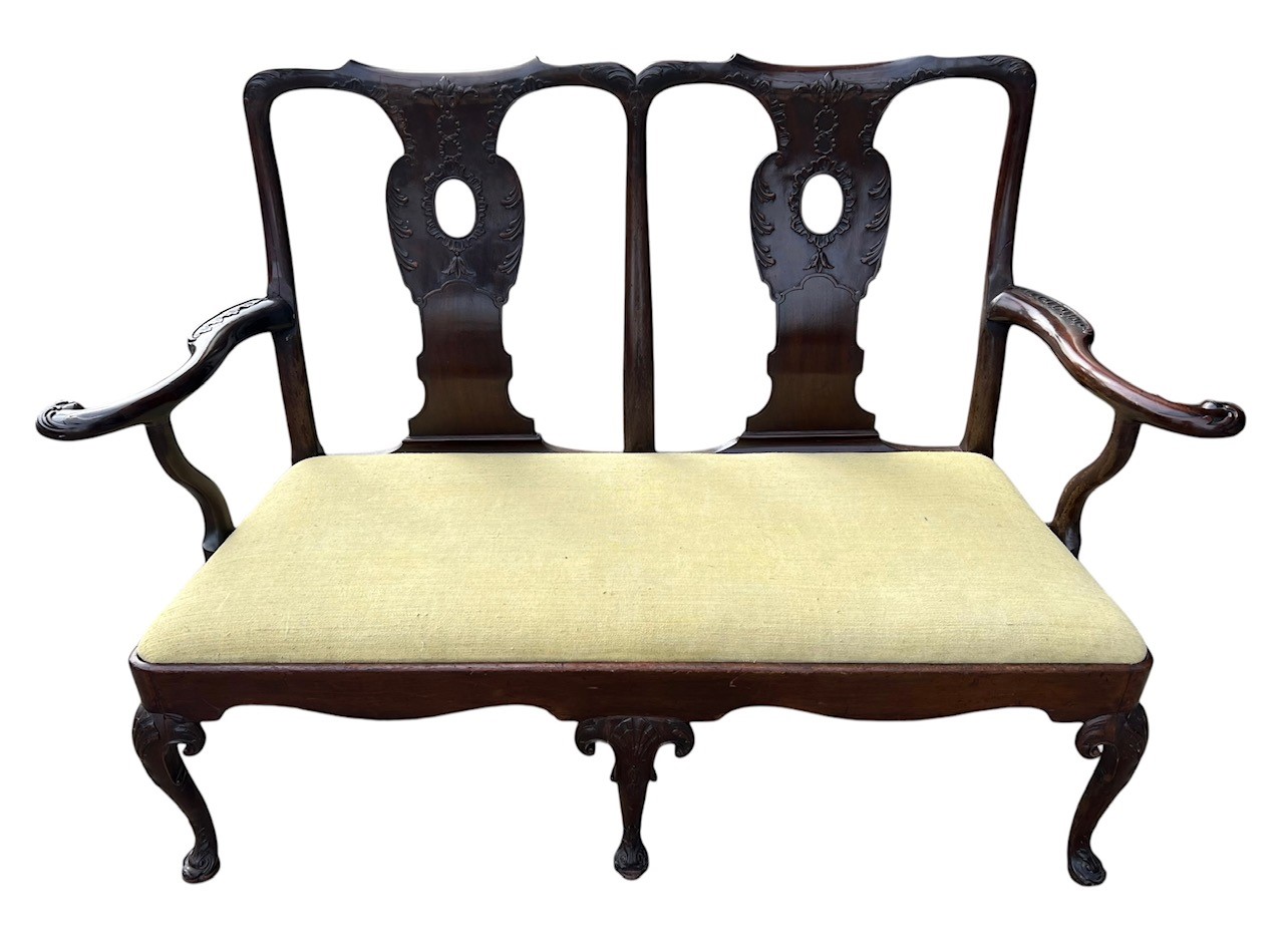 AN 18TH CENTURY IRISH CARVED MAHOGANY DOUBLE CHAIR BACK SETTEE The scrolling back and arms decorated