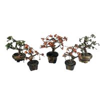 A COLLECTION OF FIVE CHINESE RED AND GREEN JASPER BONSAI TREES ON CARVED SOAPSTONE PLANTER BASES. (
