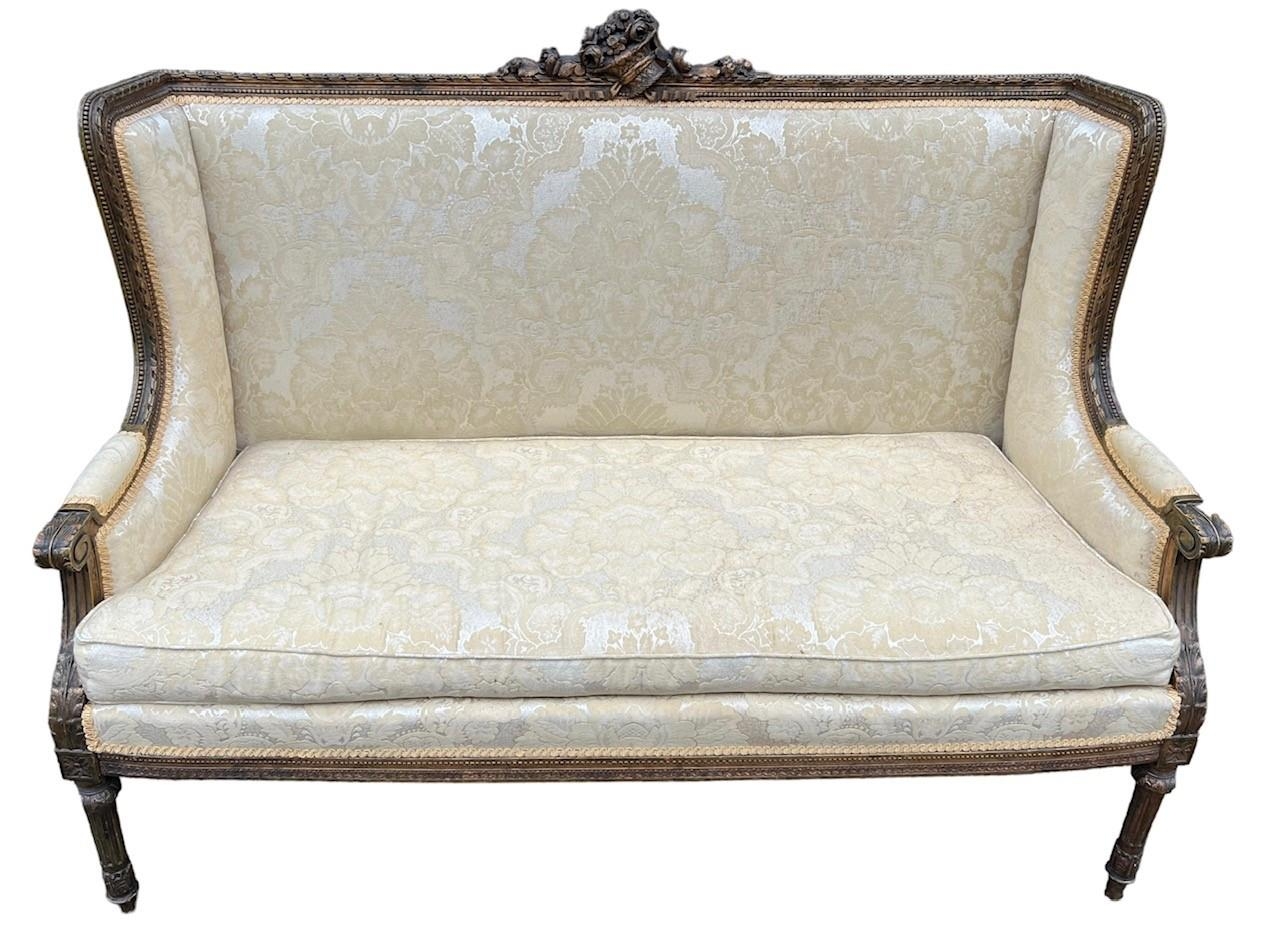 A 19TH CENTURY FRENCH LOUIS XVI DESIGN CARVED GILTWOOD WINGBACK SETTEE The back carved with a