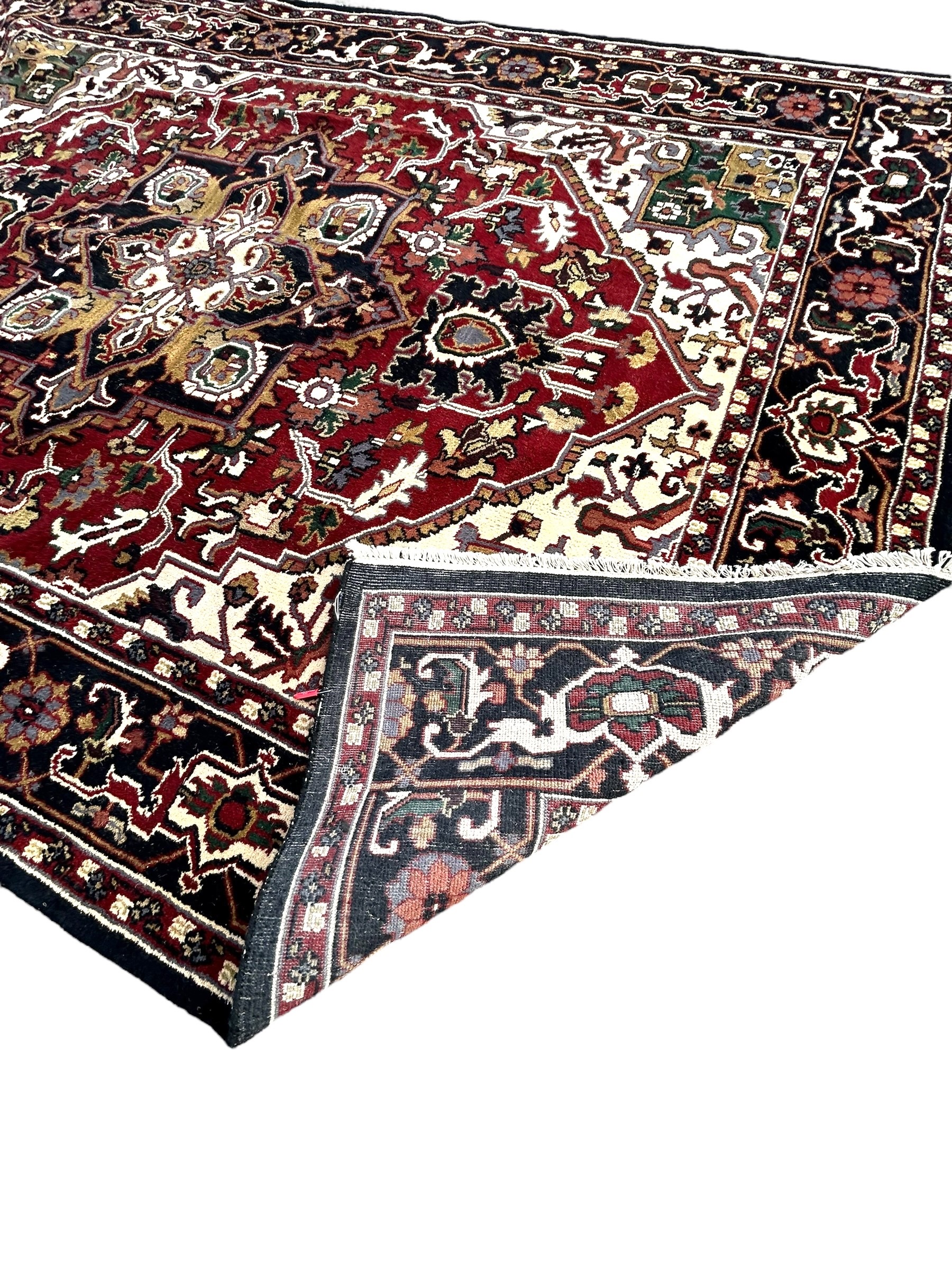 A 20TH CENTURY PERSIAN STYLE HERIZ CARPET Having central floral medallion on red and white ground, - Image 4 of 4