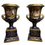 ACKERMANN & FRITZE, A PAIR OF EARLY 20TH ENTURY VIENNA STYLE TWIN HANDLED PORCELAIN URNS Decorated