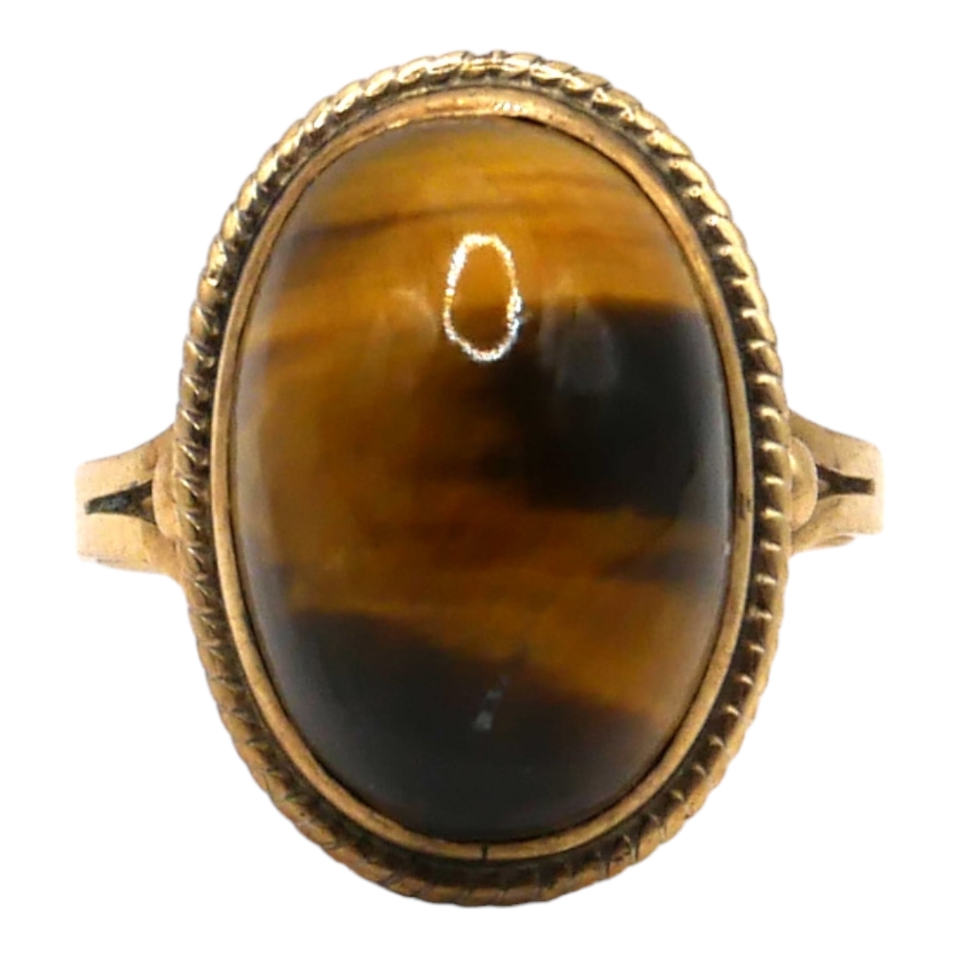 A SOUTH AFRICAN 9CT GOLD AND TIGERS EYE RING Having oval cabochon cut tiger's eye (approx 16mm x