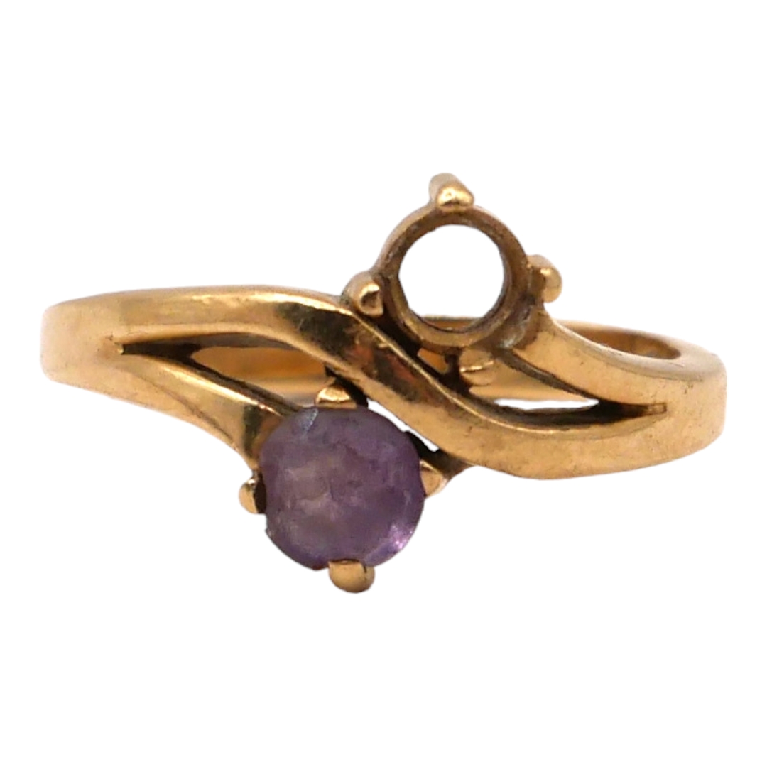 A 14CT GOLD AND AMETHYST STYLISED CROSS OVER RING Having round cut amethyst (approx. 5mm) lacking