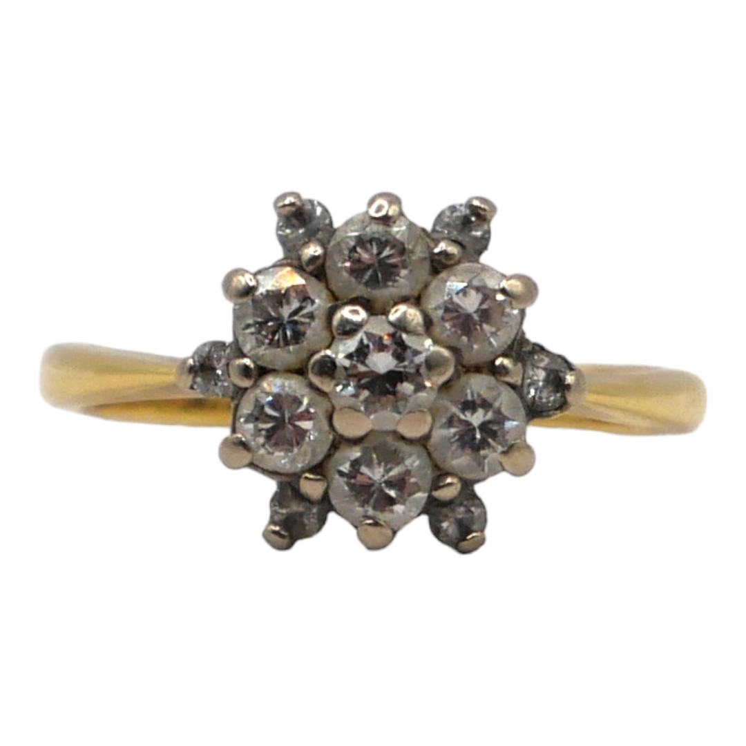 A VINTAGE 18CT GOLD AND DIAMOND CLUSTER RING The central brilliant round cut diamond (approx. 3mm)
