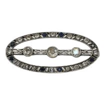 AN ART DECO WHITE METAL, DIAMOND AND SAPPHIRE OVAL BROOCH Edged with sapphire and diamonds with