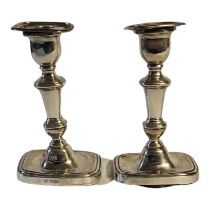 A PAIR OF EARLY 20TH CENTURY SILVER CANDLESTICKS Rectangular form with stepped base, hallmarked