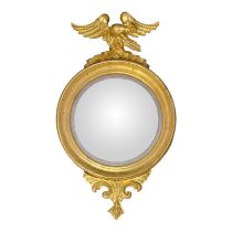 A REGENCY PERIOD GILTWOOD FRAMED CONVEX MIRROR Eagle mounted, above plate, and carved cartouche. (