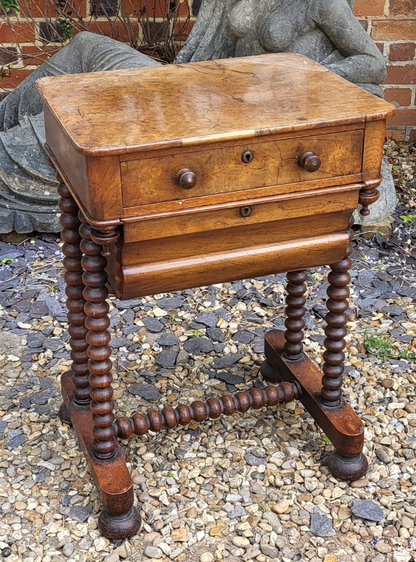 A 19TH CENTURY BURR WALNUT SEWING TABLE The compartmental drawer above a lined storage box, on
