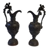 A PAIR OF CONTINENTAL BRONZE FIGURAL EWERS Classical form, with winged cherub finial,vine leaves and