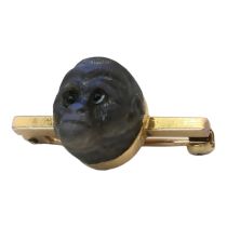 A 19TH CENTURY YELLOW METAL AND LABRADORITE 'MONKEY' BROOCH A carved head with glass set eyes on a