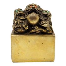 A CHINESE BRONZE DRAGON SEAL The eyes inset with coloured stones on a patinated body, with inscribed