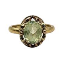 A VINTAGE YELLOW METAL AND PERIDOT RING The oval faceted stone set in a pierced design. (size N)