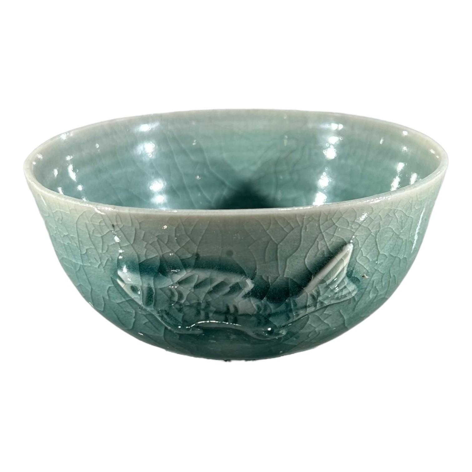 A 20TH CENTURY STUDIO POTTERY BOWL Celadon glaze, embossed fish decoration, signed indistinctly