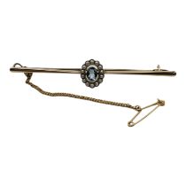 AN EDWARDIAN 9CR GOLD, BLUE TOURMALINE AND SEED PEARL BAR BROOCH Having central oval cut blue
