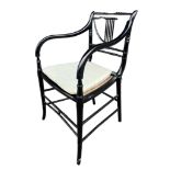 A 19TH CENTURY REGENCY FAUX BAMBOO PAINTED ARMCHAIR With cane seat and loose cushion.