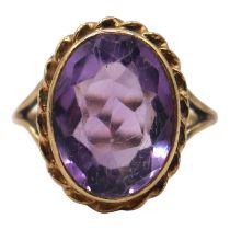 A VINTAGE 9CT GOLD AND AMETHYST RING Having central oval cut amethyst (approx. 15mm x 12mm) in bezel