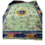 A LARGE DECORATIVE CHINESE CARPET with green ground and floral and flower decoration 275cm x 357cm