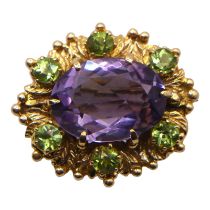 A VINTAGE 9CT GOLD, AMETHYST AND PERIDOT BROOCH Having large central oval cut amethyst (approx. 16mm