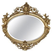 A LARGE AND IMPRESSIVE 19TH CENTURY CARVED GILTWOOD AND GESSO OVAL MIRROR With central female facial