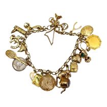 A 9CT GOLD CHARM BRACELET Having twenty three charms, mostly being 9ct gold, Belcher link chain,