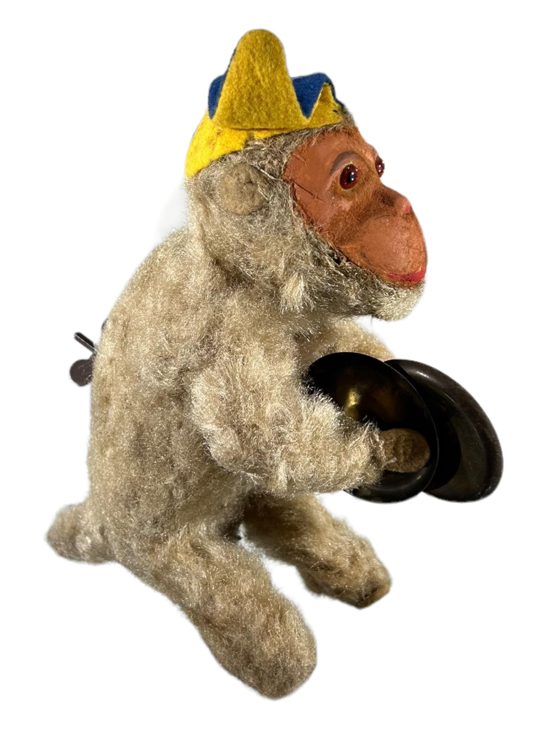 AN EARLY 20TH CENTURY MECHANICAL TOY MONKEY HOLDING SYMBOLS. (h 18cm) - Image 2 of 4