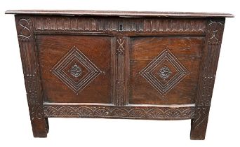 A 17TH CENTURY CARVED OAK PANELLED COFFER With hinge lid the front carved with initials ‘ST’,