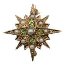 A VINTAGE 9CT GOLD, PERIDOT AND PEARL STAR BROOCH Sixteen point star having chased and engraved