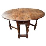 AN 18TH CENTURY OAK GATELEG TABLE The single drawer, raised on turned legs joined by stretcher. (h