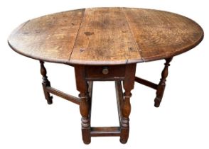 AN 18TH CENTURY OAK GATELEG TABLE The single drawer, raised on turned legs joined by stretcher. (h