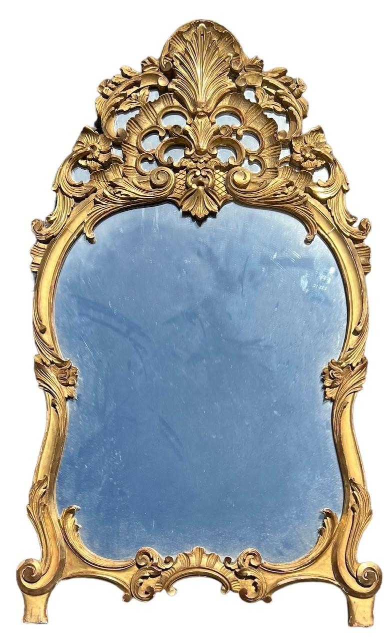 A 19TH CENTURY CARVED GILTWOOD ROCOCO DESIGN MIRROR The frame decorated with scrolling foliage and