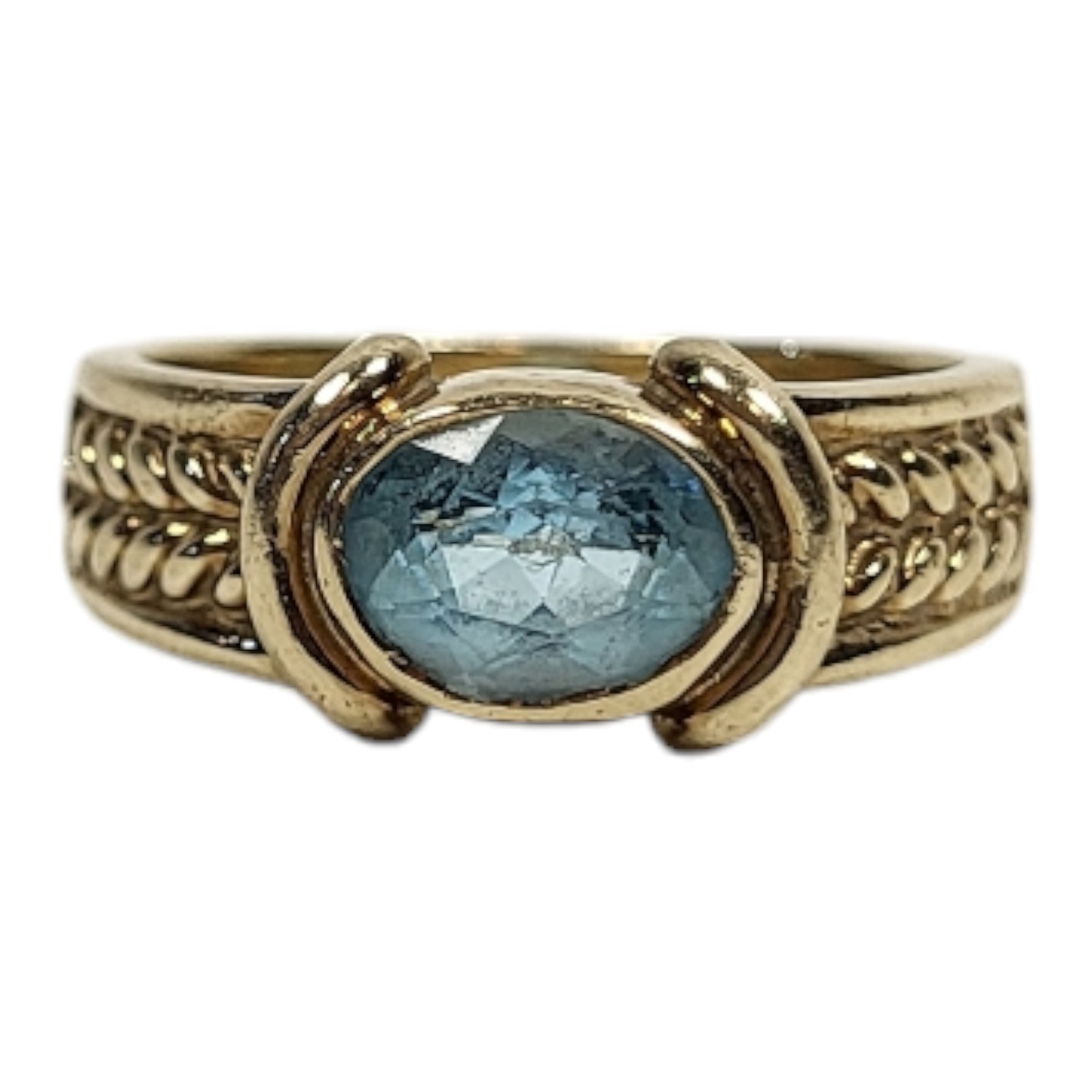 A VINTAGE 9CT GOLD AND AQUAMARINE RING The oval cut stone with wheatsheaf design to shoulders. (size