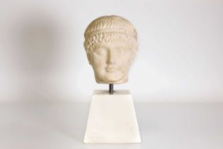 A Greek-style carved marble bust of a boy,