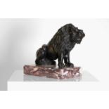 A bronze model of a crouching lion,