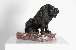 A bronze model of a crouching lion,