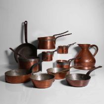 A large group of copper kitchen pans and kettles,