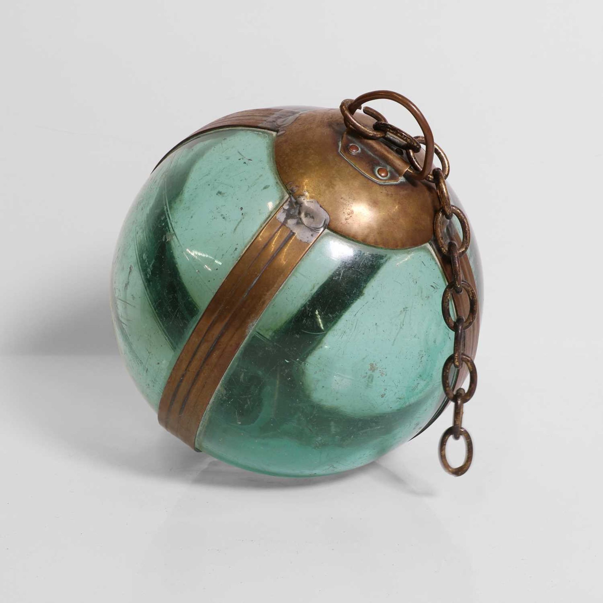 A brass-mounted pale-green glass buoy or fishing float,