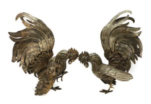 A pair of silvered fighting cockerels