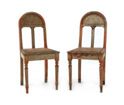 A pair of painted and distressed wooden side chairs,
