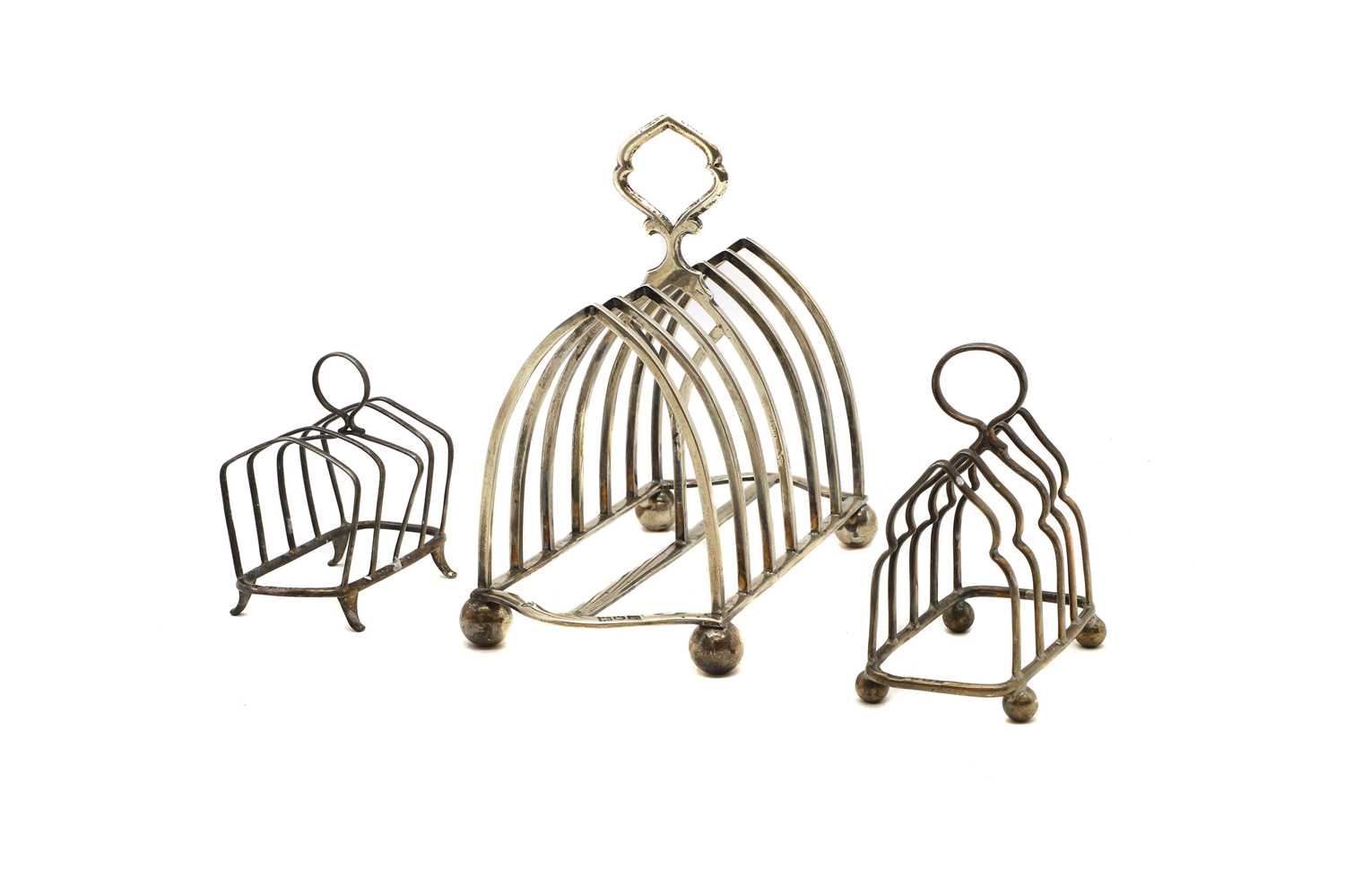 A group of three silver toast racks