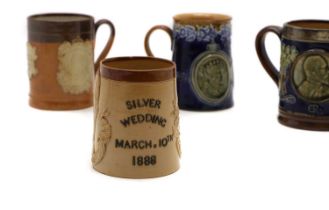 A group of four commemorative stoneware commemorative mugs