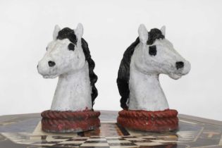 A pair of painted composite stone horse heads,