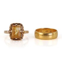A gold wedding band and a gold citrine ring,