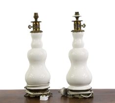A pair of earthenware and brass mounted table lamps,