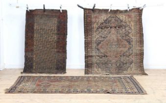 Three well-worn country house rugs