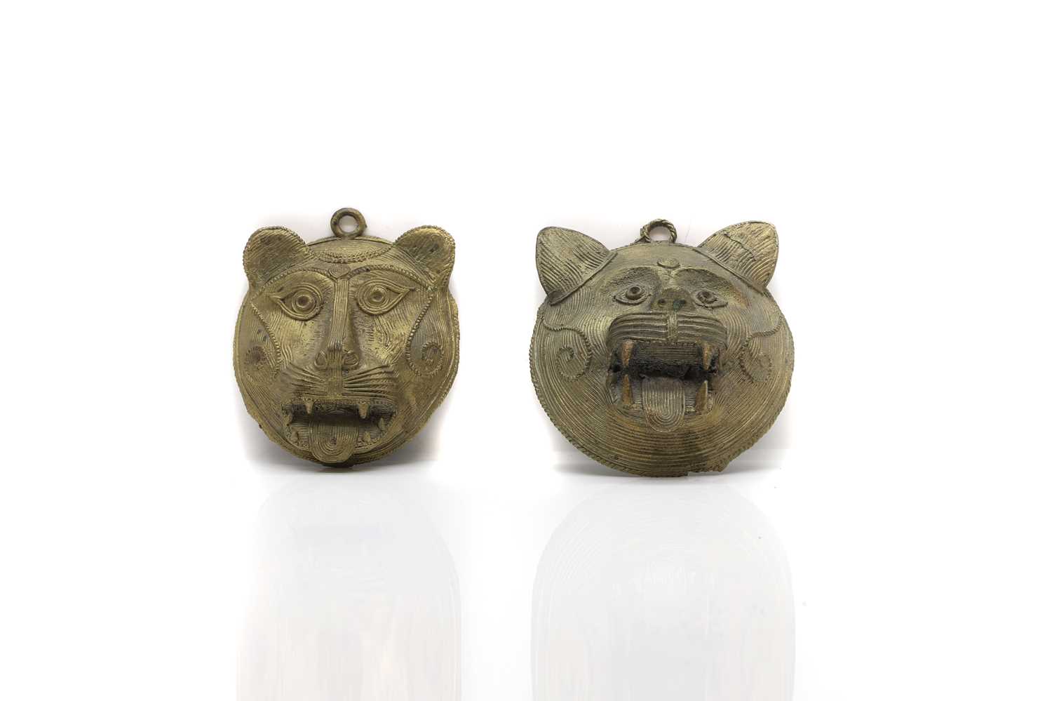 A pair of Indian brass masquettes,