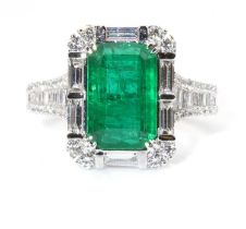 A white gold emerald and diamond cluster ring,