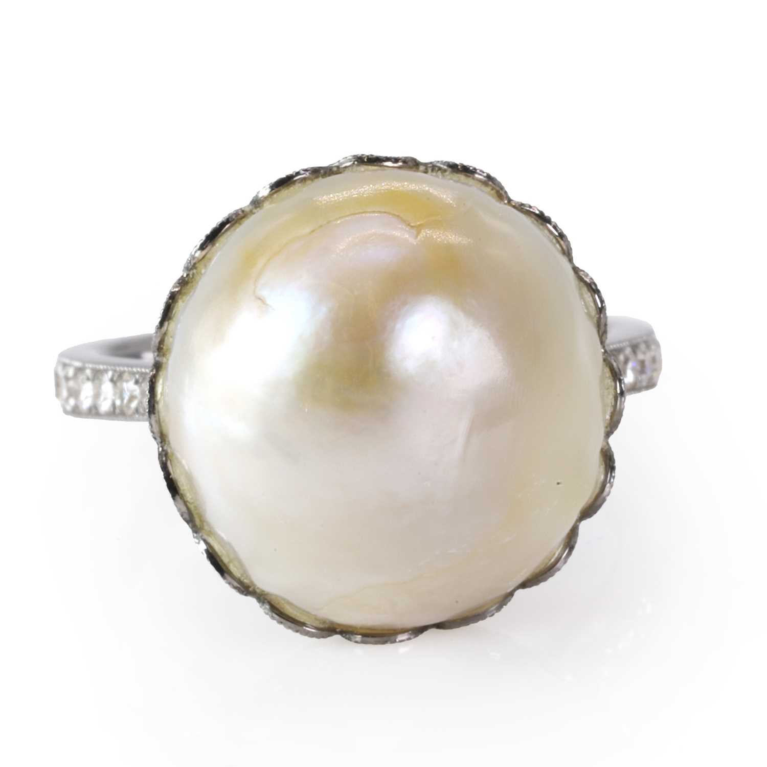A large natural saltwater pearl ring with diamond set shoulders,