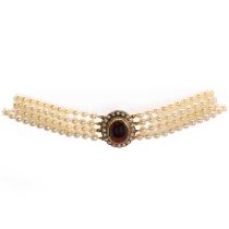 A uniform four row cultured pearl necklace with a garnet set clasp,