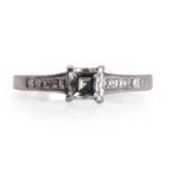 A platinum single stone diamond ring with diamond set shoulders,